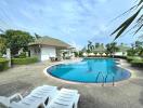 Outdoor pool with lounge chairs and greenery