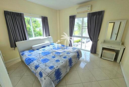 Bright bedroom with large windows and blue floral bedding