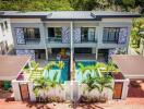 Exterior view of a modern two-story duplex with a swimming pool and covered parking spaces