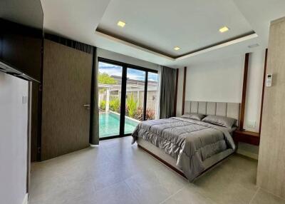 Modern bedroom with pool view and large glass door