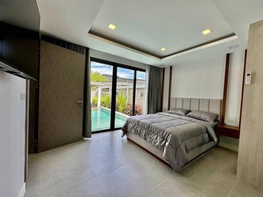 Modern bedroom with pool view and large glass door