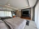 Spacious modern bedroom with large TV and mirrored wardrobe