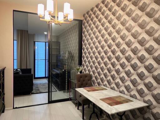 Modern dining area with patterned wallpaper and glass partition