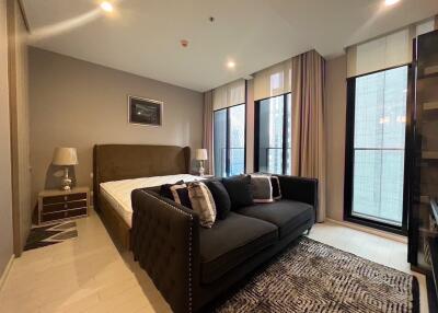 Modern bedroom with large windows, bed, sofa and nightstands