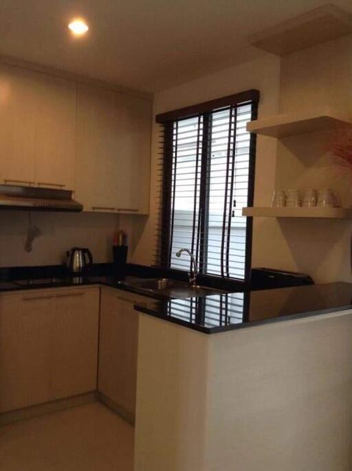 Modern kitchen with wooden cabinets and black countertops