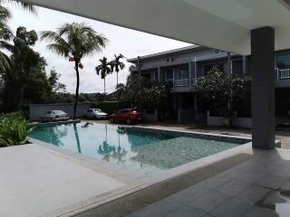 Outdoor pool area with parked cars and residential building