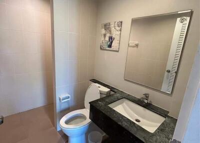 Modern bathroom with sink, toilet, and mirror