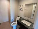 Modern bathroom with sink, toilet, and mirror