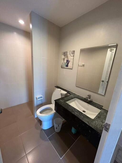 Modern bathroom with sink, toilet, and mirror