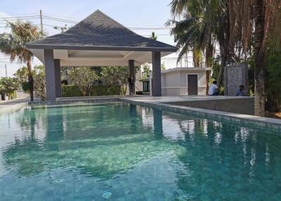 Outdoor swimming pool area with poolside seating and shelter