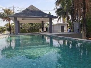 Outdoor swimming pool area with poolside seating and shelter