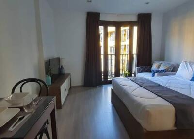Spacious bedroom with a large bed, balcony access, and dining area