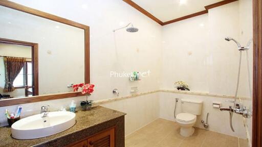 Modern bathroom with large mirror, shower, and toilet