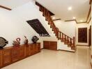 Well-lit hallway with wooden staircase and decorative items