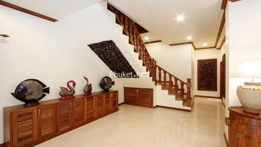 Well-lit hallway with wooden staircase and decorative items