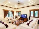 Well-furnished living room with cream sofas, wooden furniture, and a TV