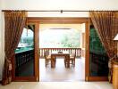 Living room opening to a furnished balcony with a view