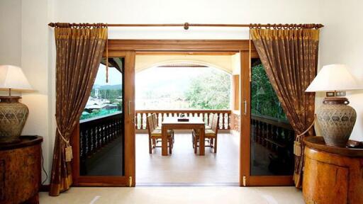 Living room opening to a furnished balcony with a view