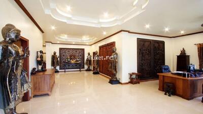 Spacious and elegantly decorated living room with ornamental statues and wooden furnishings