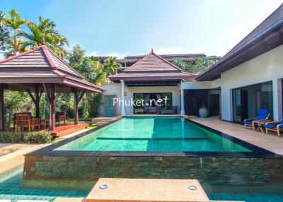 Luxurious outdoor pool area with seating and greenery