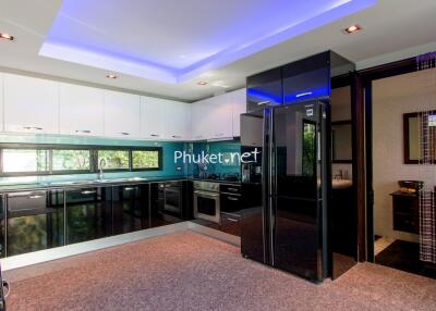 Modern kitchen with black and white cabinetry and blue accent lighting