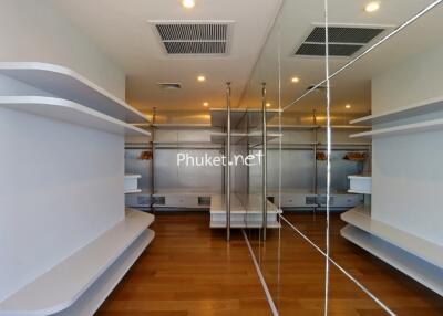 Spacious walk-in closet with wooden flooring and ample shelving