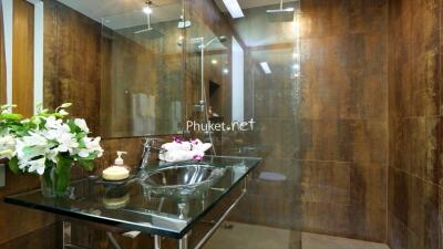 Modern bathroom with glass sink and a floral arrangement