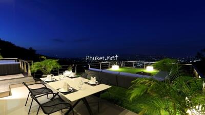 Outdoor terrace with patio furniture and city view at night