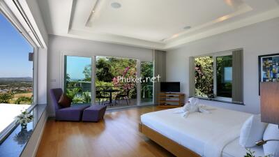 Spacious bedroom with large windows and balcony view