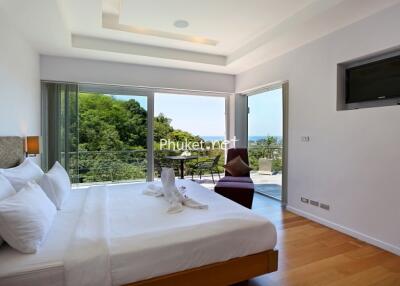 Modern bedroom with large windows and a scenic balcony view