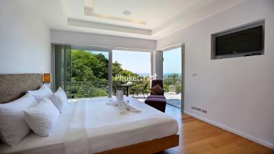 Modern bedroom with large windows and a scenic balcony view