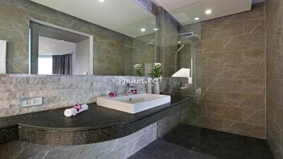 Modern bathroom with stone tiles and glass shower