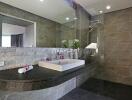 Modern bathroom with stone tiles and glass shower