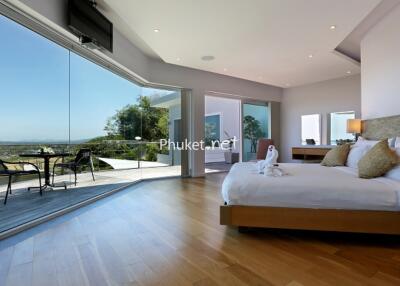 Spacious bedroom with large windows and scenic view