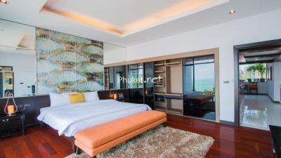 Spacious modern bedroom with wooden flooring, large bed, and a view