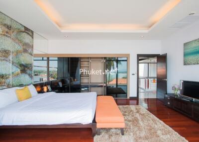Modern bedroom with large bed, wall art, and sliding glass doors.