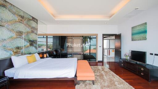 Modern bedroom with large bed, wall art, and sliding glass doors.