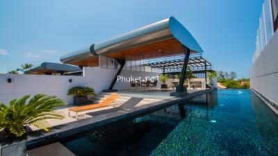 Modern outdoor pool area with lounge chairs and covered seating