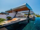 Modern outdoor pool area with lounge chairs and covered seating