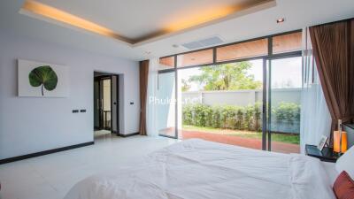 Modern bedroom with large windows and garden view