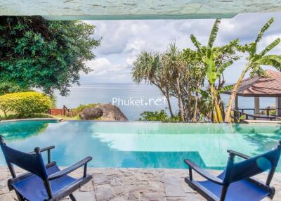 Outdoor pool overlooking the ocean with seating area