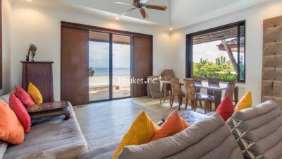 Well-lit living area with ocean view and colorful cushions