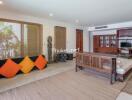 Spacious living room featuring comfortable wooden furniture and vibrant decorative elements