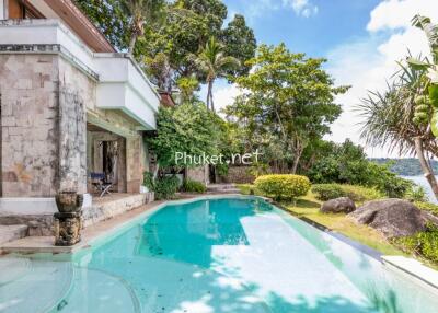 Outdoor pool area with surrounding greenery and water view