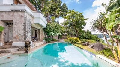 Outdoor pool area with surrounding greenery and water view