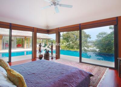 Modern bedroom with a view of the pool and surrounding greenery