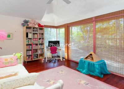 Bedroom with large windows, a sofa, a bookcase, and a TV