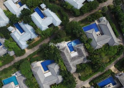 Aerial view of a neighborhood with multiple houses and swimming pools