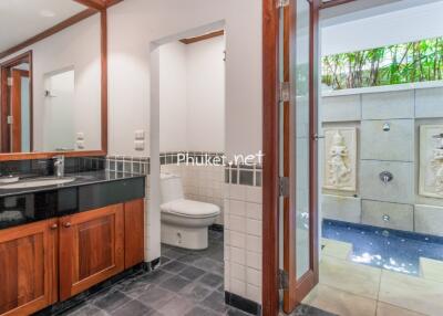 Bathroom with black granite counter, large mirror, and adjoining outdoor shower area