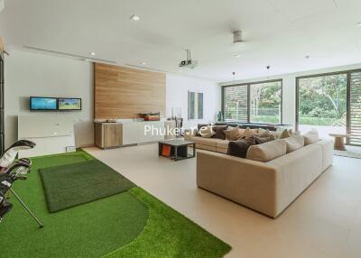 Spacious modern living room with large windows and golf equipment